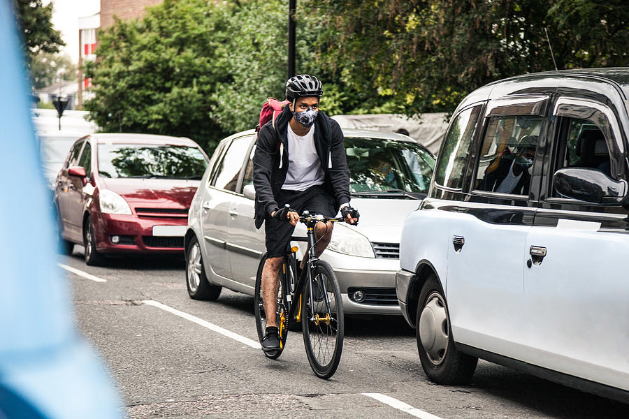 Cyclist commuter wearing a pollution-mask in Central London Photograph by LeoPatrizi