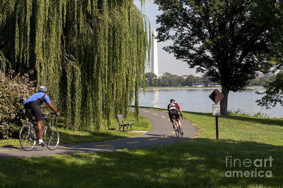 Cyclists on bike path with Washington Monument in background across the Potomac Photograph by William Kuta