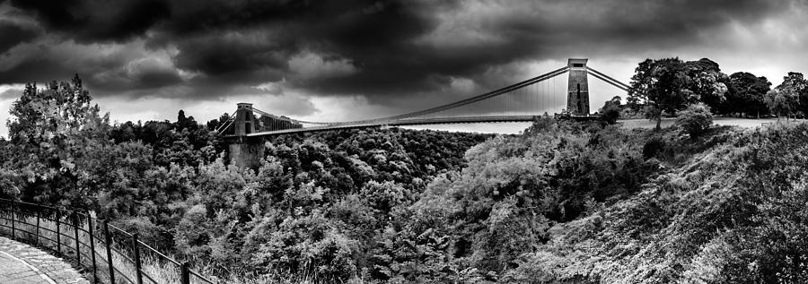 Architecture Photograph - Dark Clouds Over A Suspension Bridge by Panoramic Images