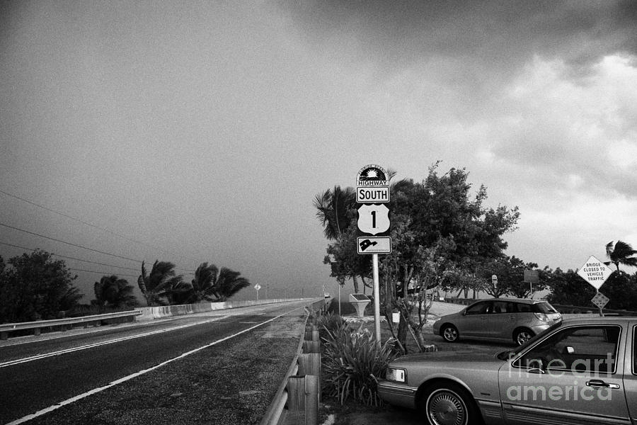 Key Photograph - Dark Rain Storm Clouds Blow Over The Seven Mile Bridge Marathon Key Car Park Florida Keys Usa by Joe Fox