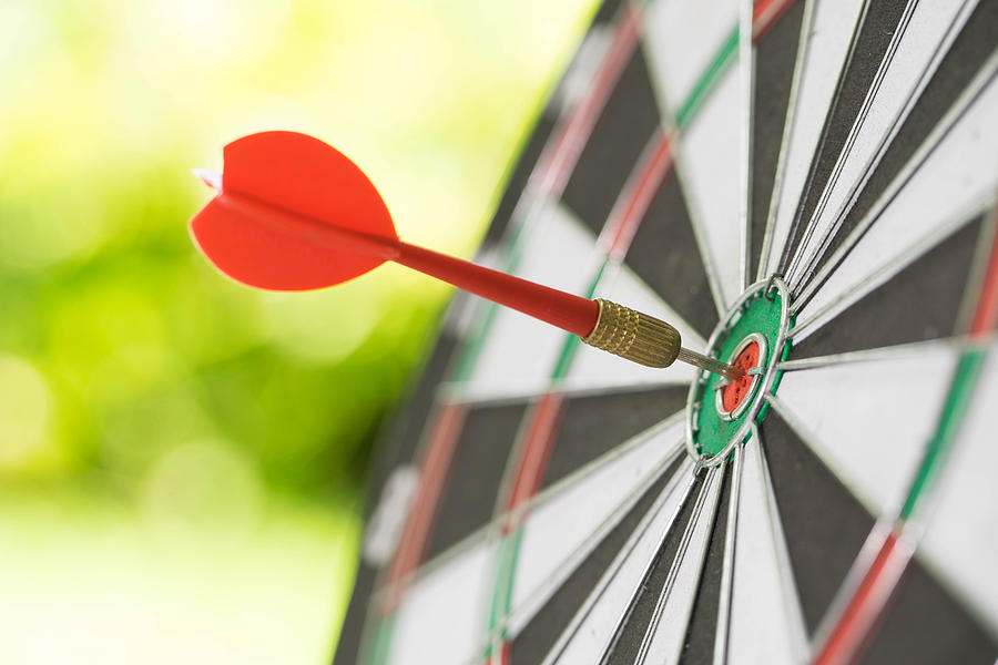Darts in center of the target dartboard on a light green background Photograph by Krisanapong Detraphiphat