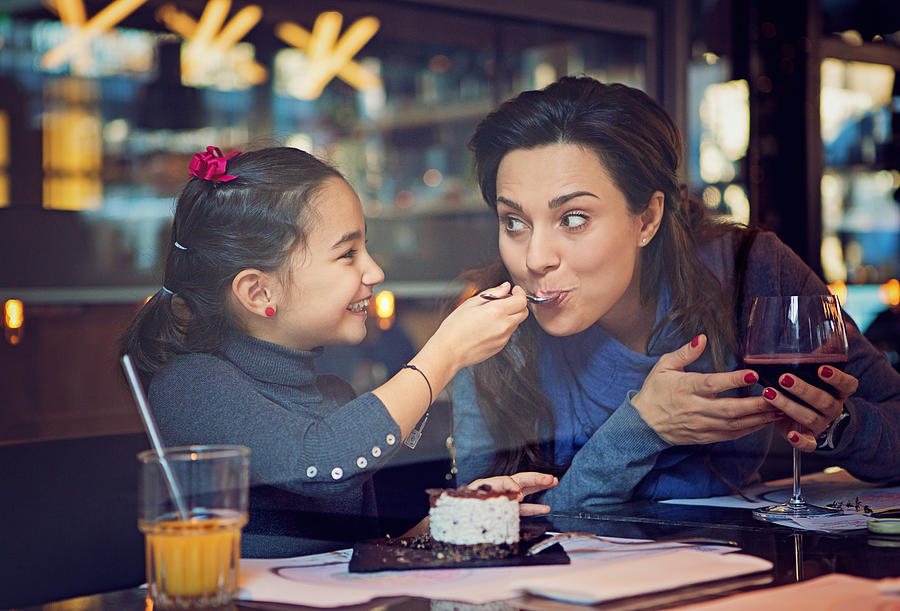 Daughter is feeding her mother with cake Photograph by Praetorianphoto