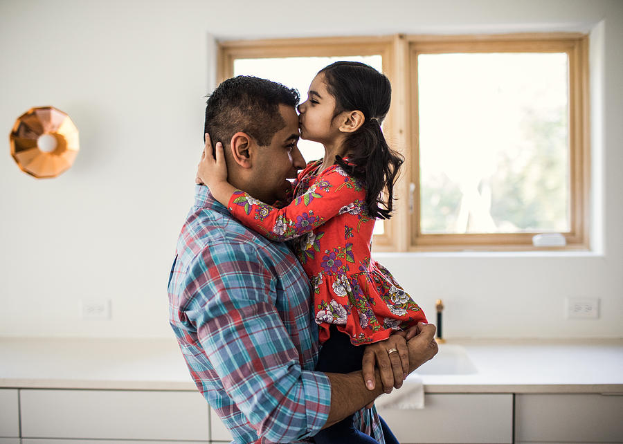 Daughter kissing father at home Photograph by MoMo Productions