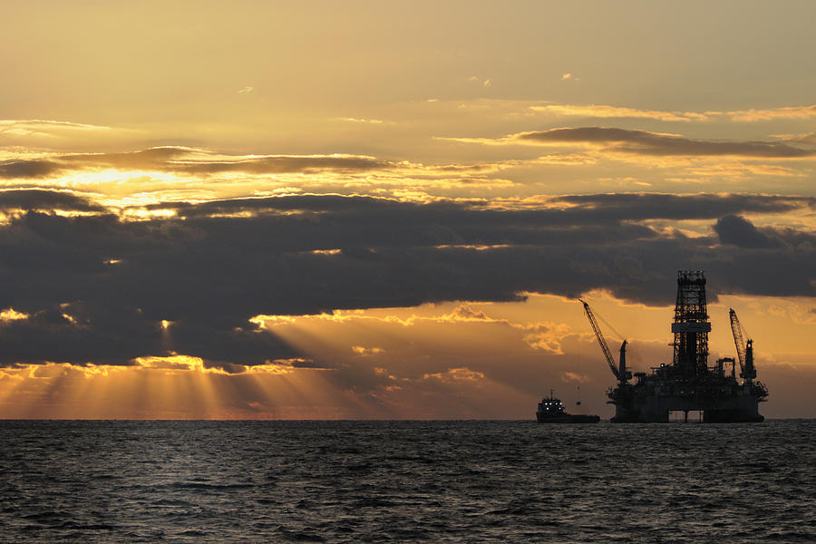 Dawn at the oil rig Photograph by Bradford Martin