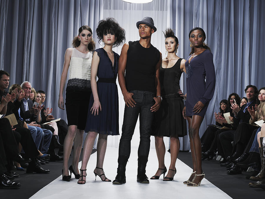 Designer and female models standing on catwalk Photograph by Thomas Barwick