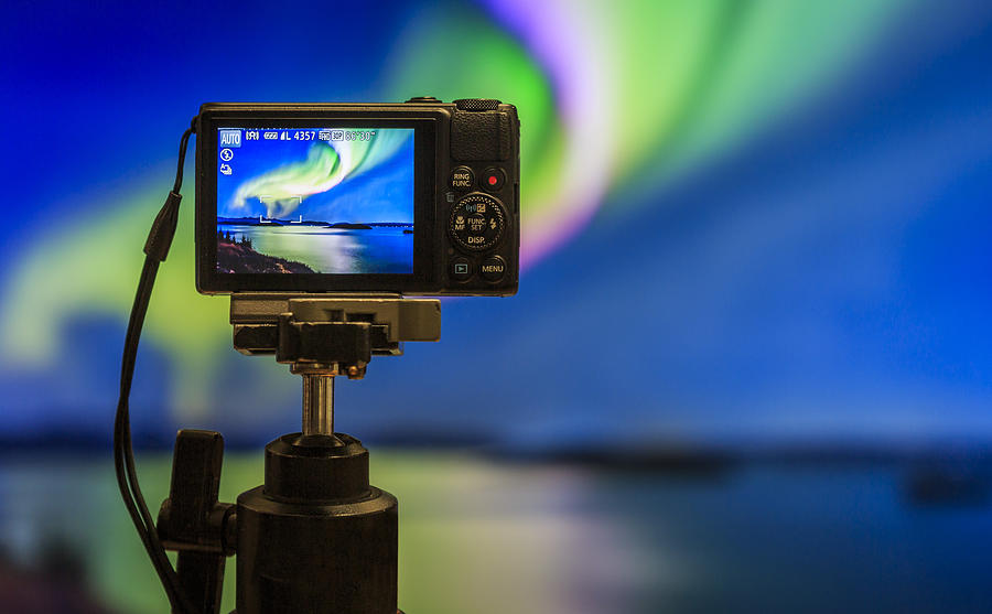 Digital camera on tripod  photographing Auroras. Photograph by Arctic-Images