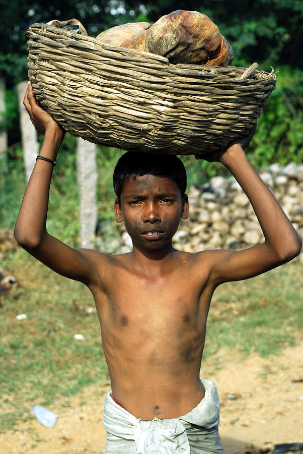 Dirty child carrying items gathered in third world country Photograph by Likhitha