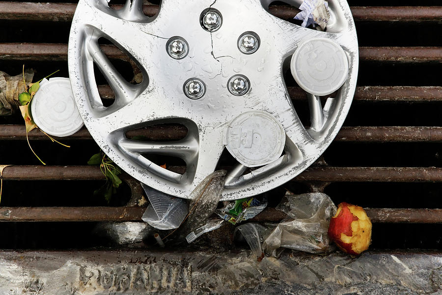 Apple Photograph - Discarded Hubcap And Litter On A Storm by Ron Koeberer