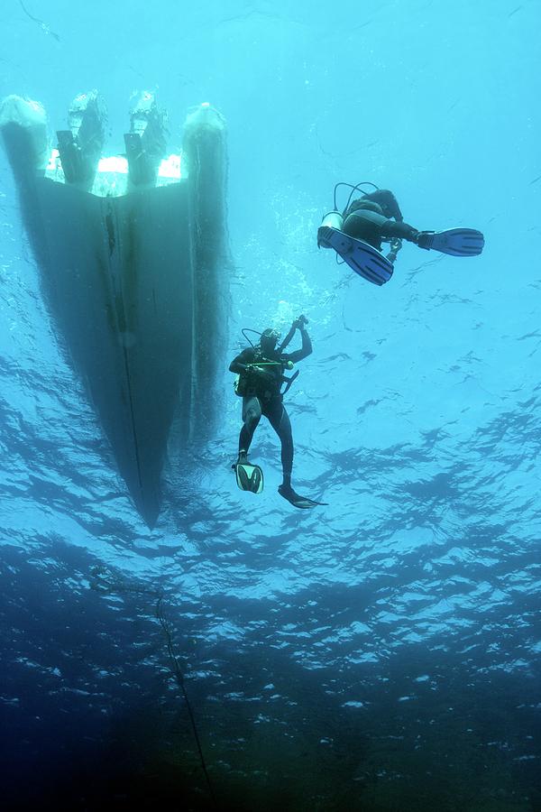 Divers Descending From A Boat Photograph by Louise Murray