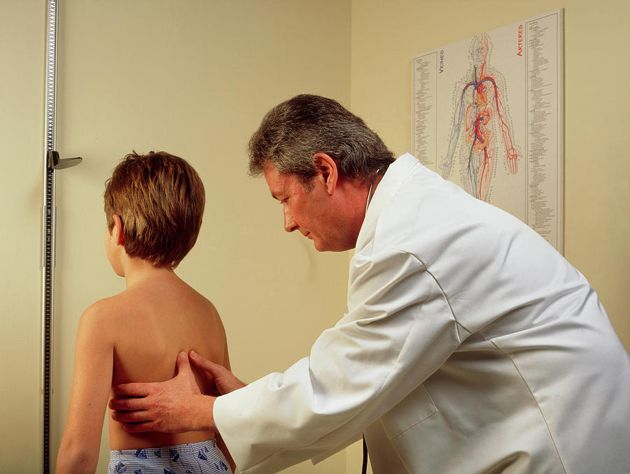 Doctor Examining The Spine/chest Of A Young Boy by Cc Studio/science Photo  Library