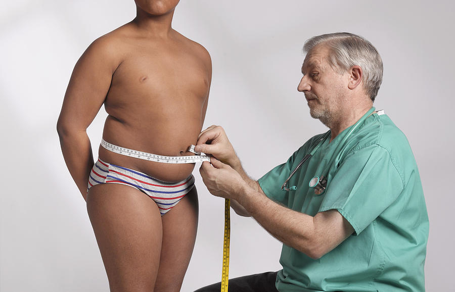 Doctor measuring overweight boy Photograph by Peter Dazeley