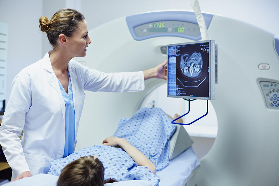 Doctor showing CT scan to patient Photograph by Morsa Images
