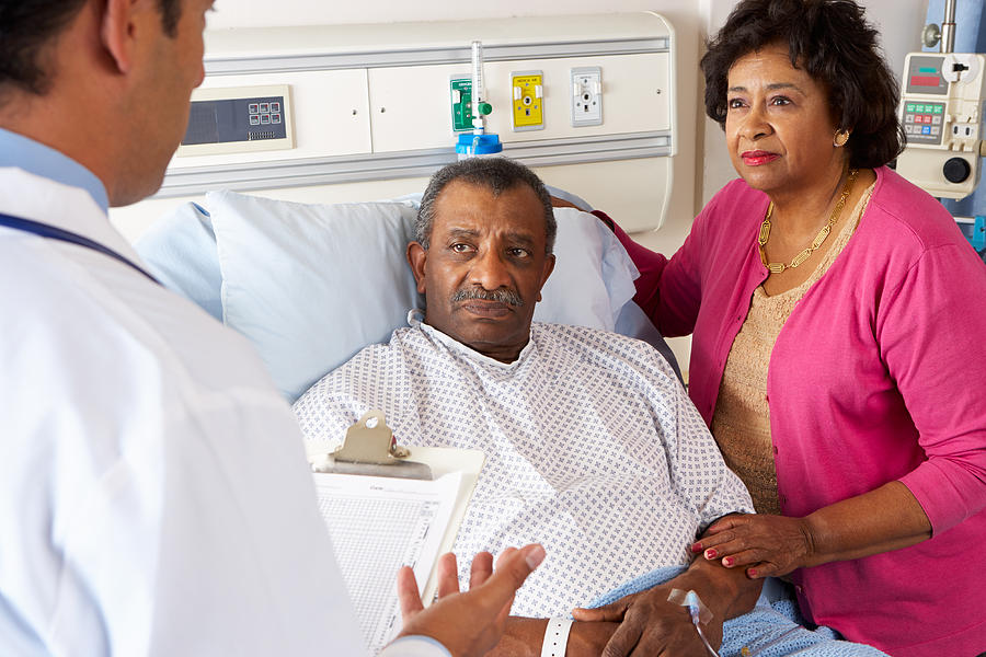Doctor Talking To Senior Couple On Ward Photograph by Monkeybusinessimages