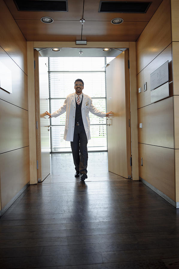 Doctor walking in office hallway Photograph by Suedhang