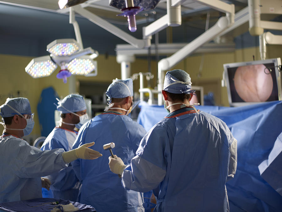 Doctors performing arthroscopic surgery Photograph by John P Kelly