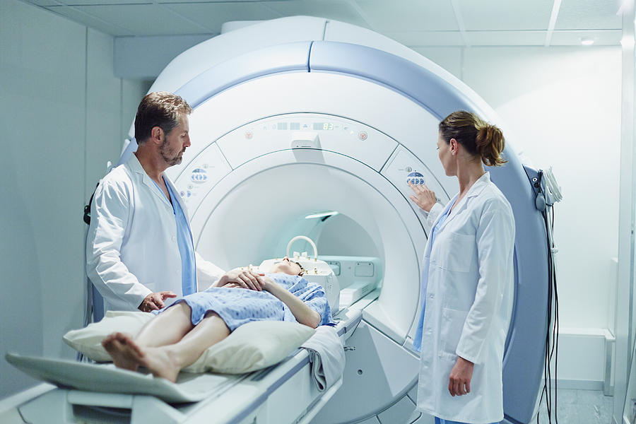 Doctors preparing patient for MRI scan Photograph by Morsa Images
