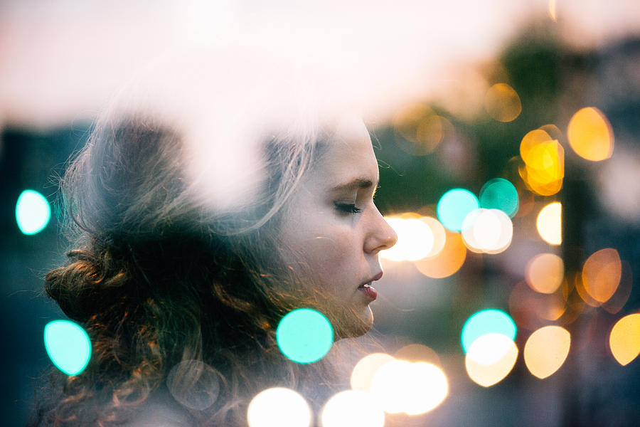 Double exposure of young woman with bokeh city lights. Photograph by Gabriela Tulian