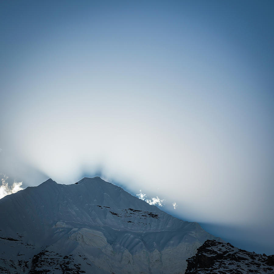 Dramatic Light Rays Over Snow Capped Photograph by Fotovoyager
