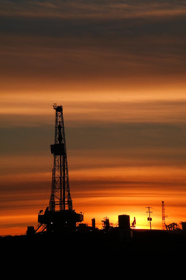 Dusk and an oil rig Photograph by Jeff Swan