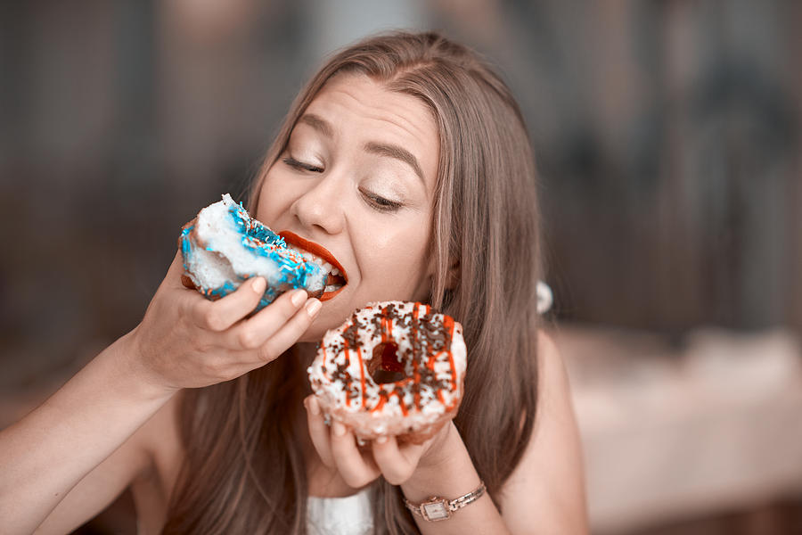 Eating Delicious Donuts Photograph by Stock_colors