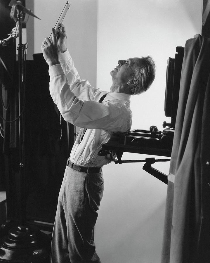 Edward Steichen Examining A Negative Photograph by George Hoyningen-Huene