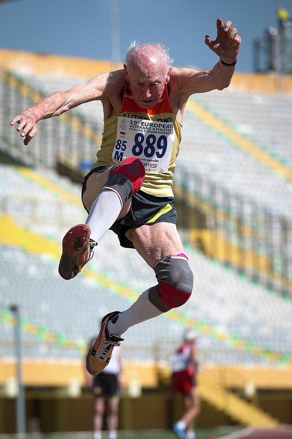 Elderly Male Athlete Jumping Mid-air Photograph by Alex Rotas