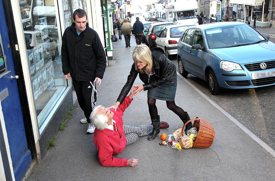 Elderly Woman Being Helped After Falling Photograph by Mark Thomas/science Photo Library