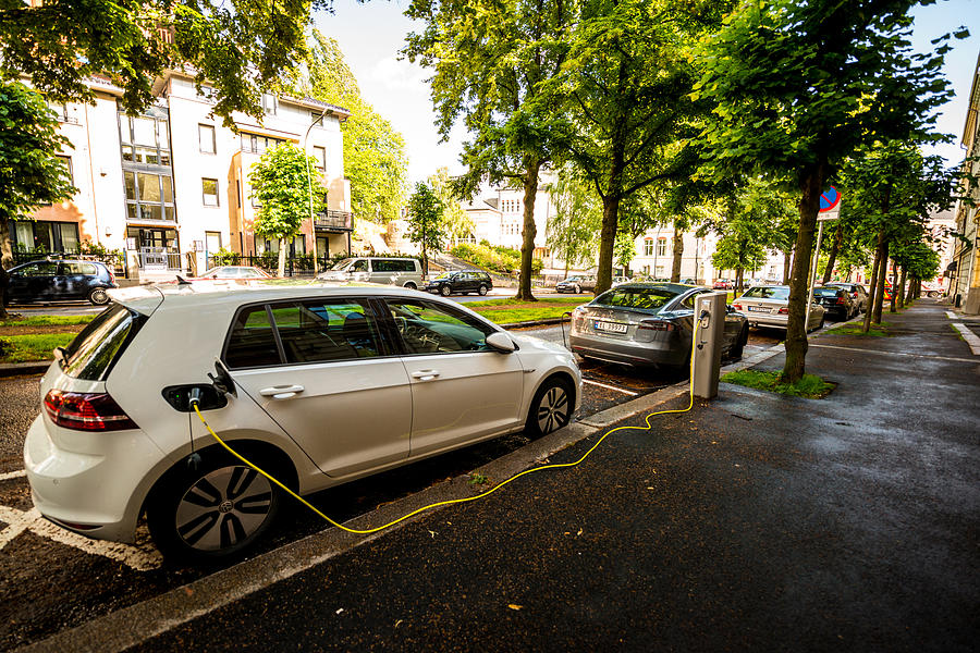 Electric car  is charging on Oslo street, Norway Photograph by Anouchka