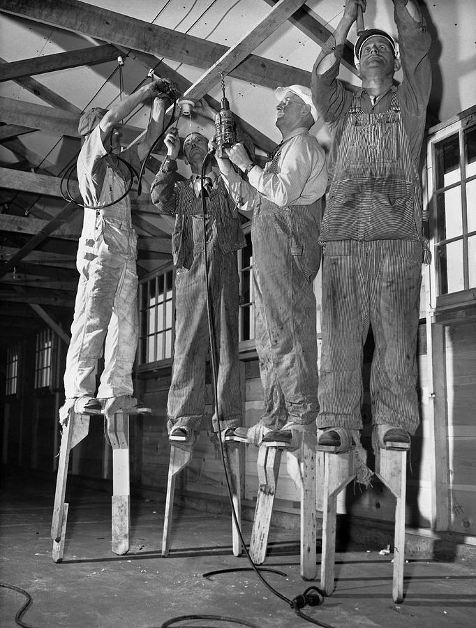 Electricians On Stilts Photograph by Underwood Archives