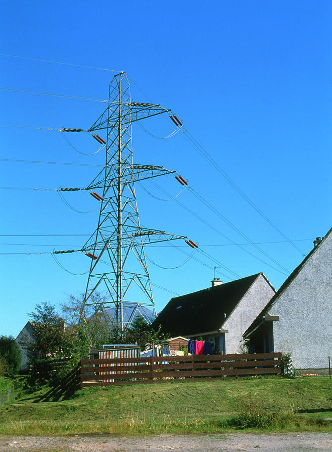 Electricity Pylons & Cables Over Village Photograph by Simon Fraser
