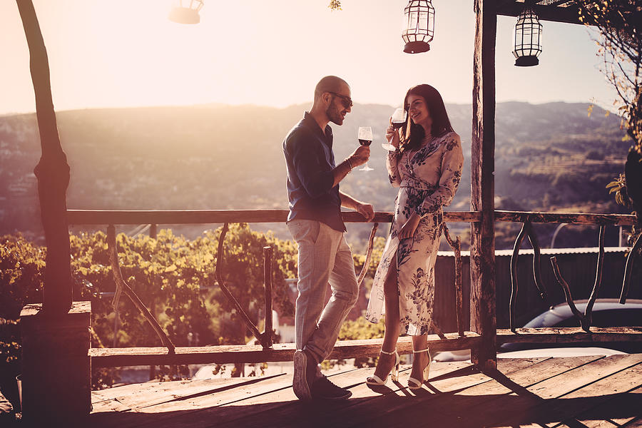 Elegant couple drinking red wine at French rustic vineyard winery Photograph by Wundervisuals