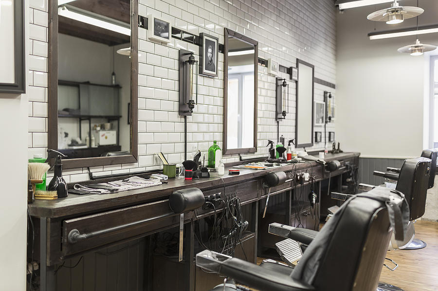 Empty chairs in front of mirrors at barber shop Photograph by Vladimir Godnik