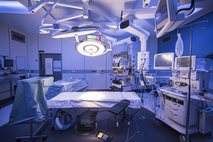 Empty hospital operating theatre with lighting over bed Photograph by JohnnyGreig
