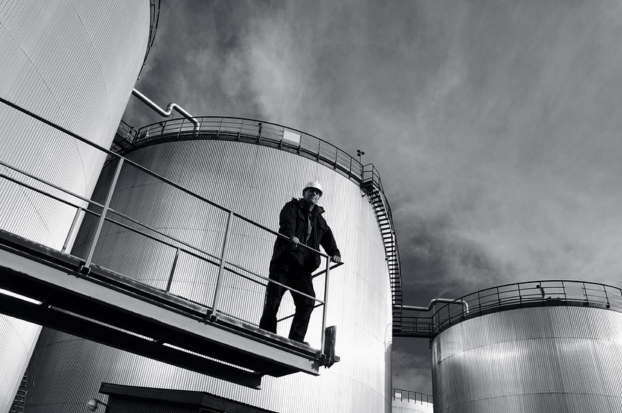 Engineer With Large Oil Towers Photograph by Christian Lagereek