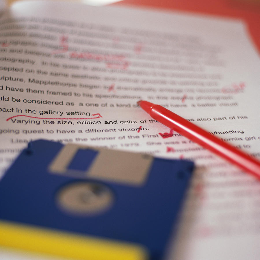 Essay paper with floppy diskettes lying on top, red pen beside them Photograph by Stockbyte