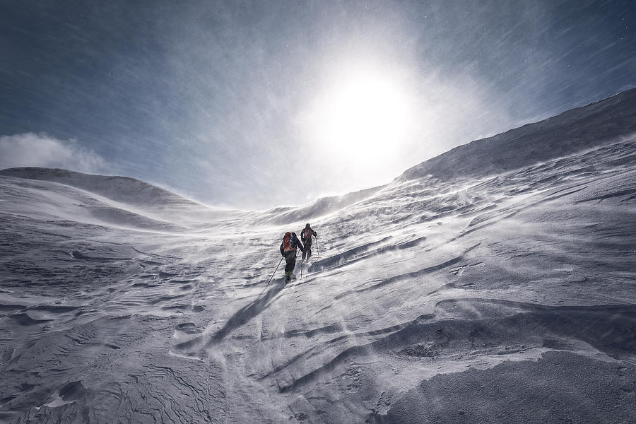 Explorer on skiing tour with icy snowstorm Photograph by Martin Steinthaler