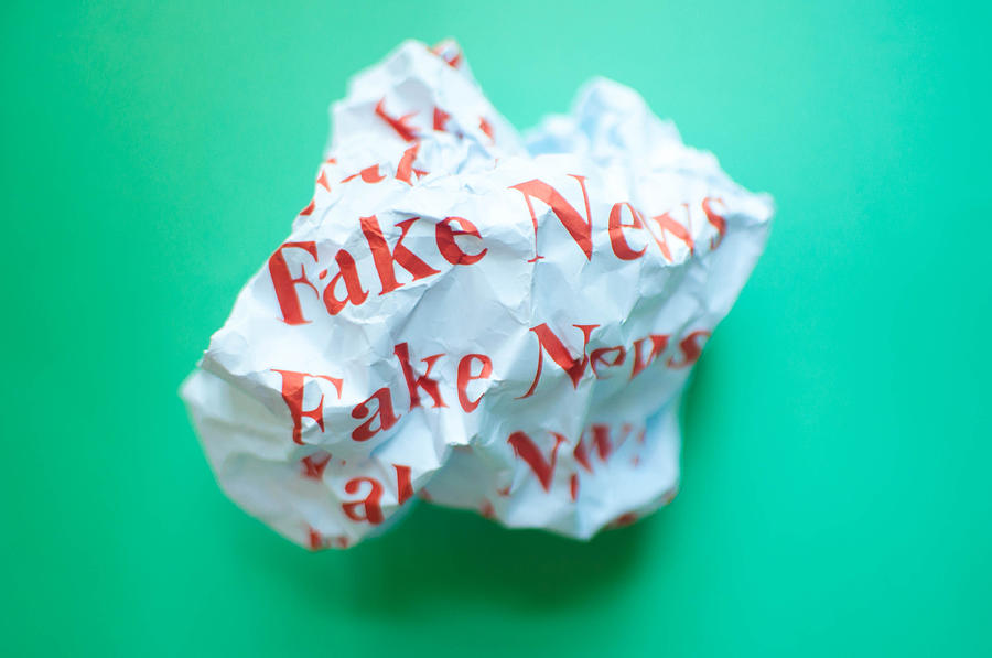 Fake news against blue green background Photograph by Karl Tapales