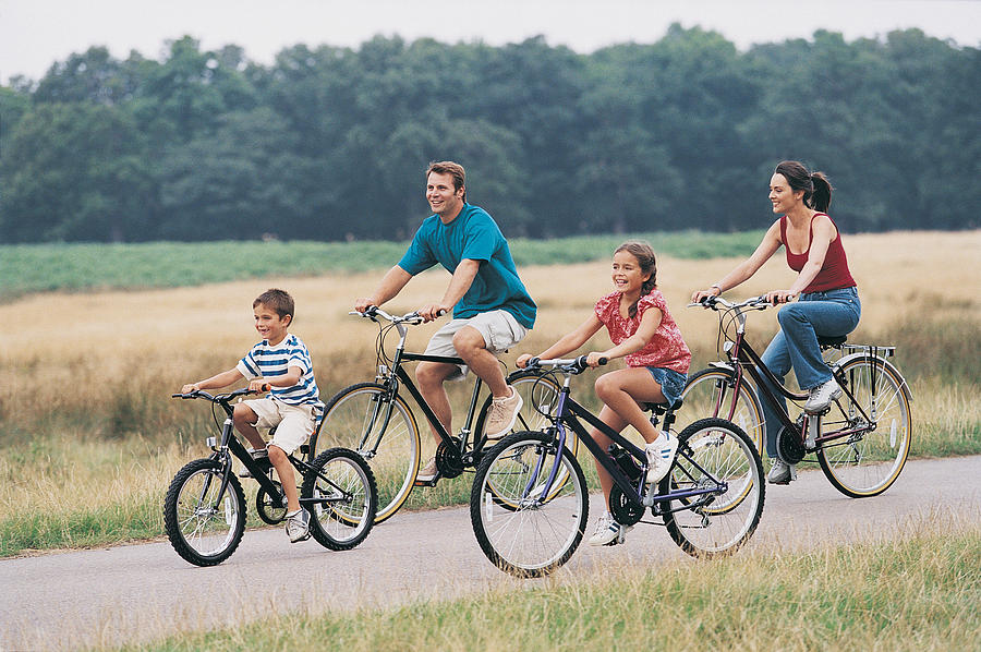Family Cycling on a Country Road Photograph by Digital Vision.