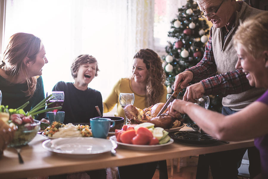 Family having Christmas dinner Photograph by MilosStankovic
