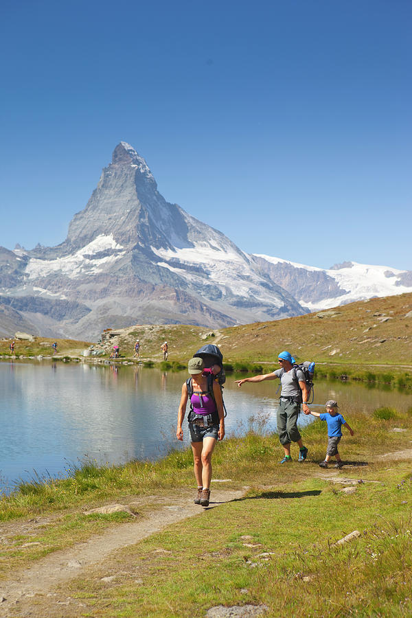 Family Hiking On Lakeshore In Swiss Photograph by Menno Boermans | Fine ...