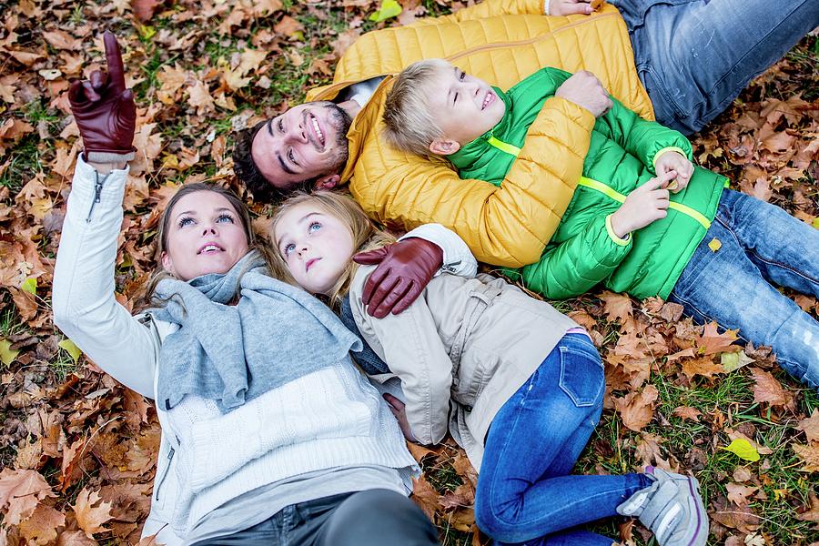 Family Lying On Dried Leaves Photograph by Science Photo Library
