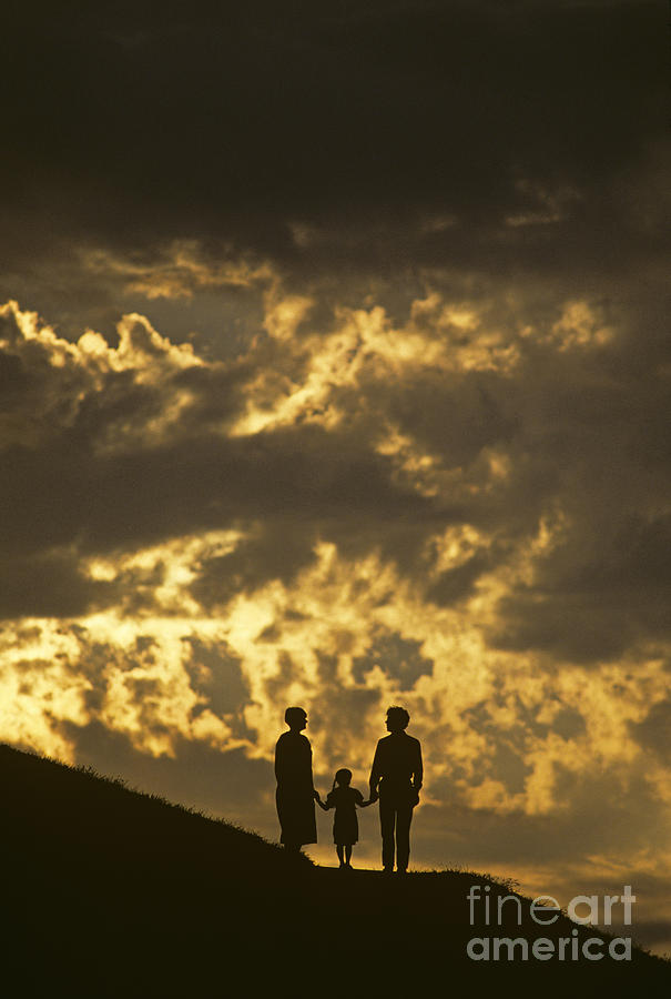 Family on hillside holding hands and facing life together. Photograph by Jim Corwin