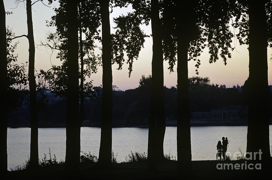 Family silhouetted by lake Photograph by Jim Corwin