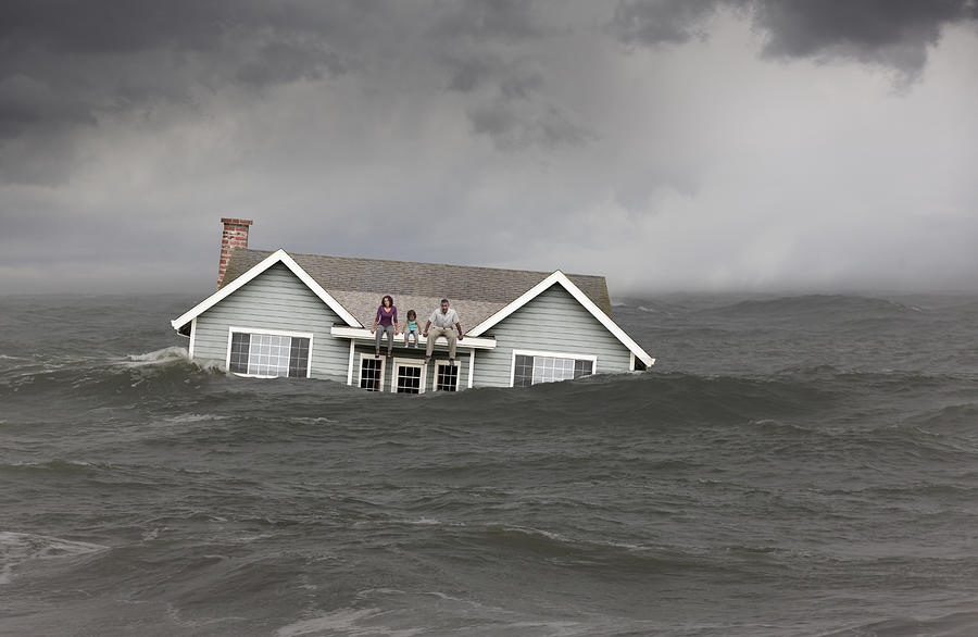 Family sitting on roof of house floating in sea Photograph by John M Lund Photography Inc