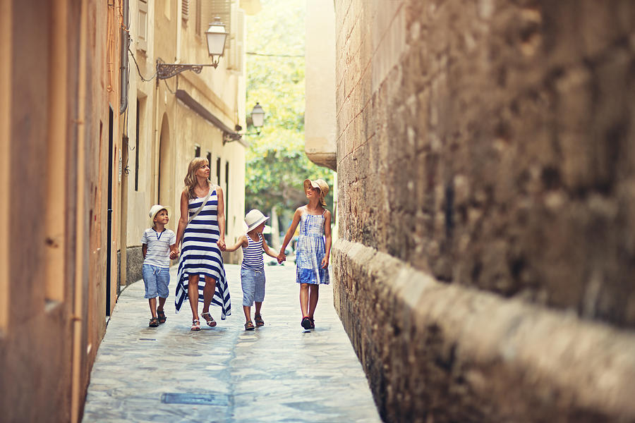 Family walking narrow street of  Palma de Mallorca, Spain Photograph by Imgorthand