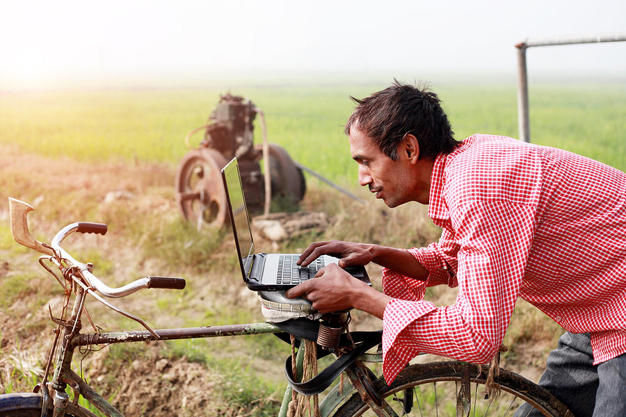 Farmer using laptop in the field Photograph by Pixelfusion3d