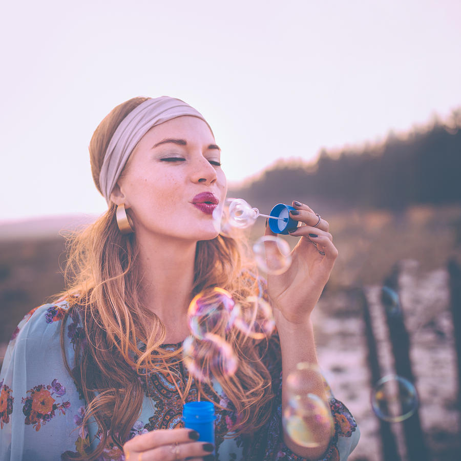 Fashion Boho girl blowing bubbles in nature Photograph by Wundervisuals