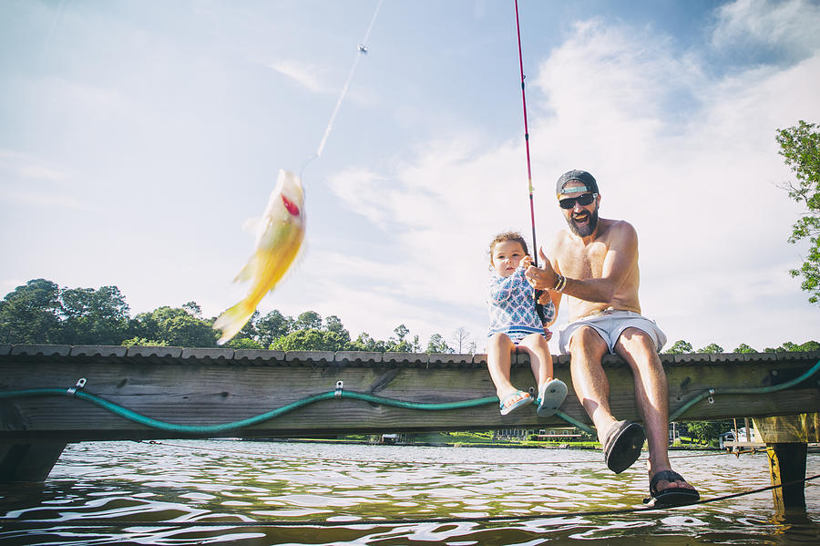 Father and daughter reeling in fish at Lake Jackson, Atlanta, Georgia, USA Photograph by Romona Robbins Photography
