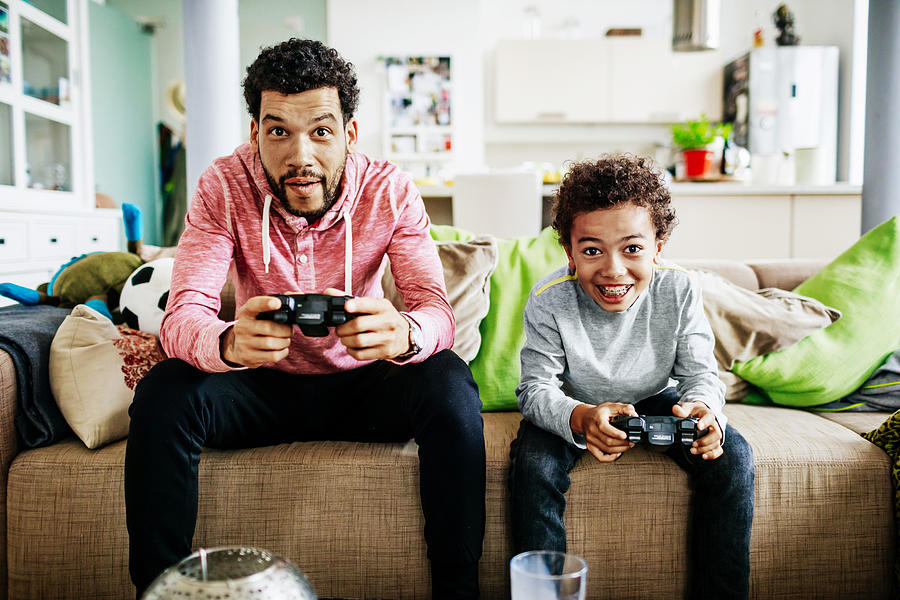 Father And Son Concentrating While Playing Video Games Together Photograph by Tom Werner
