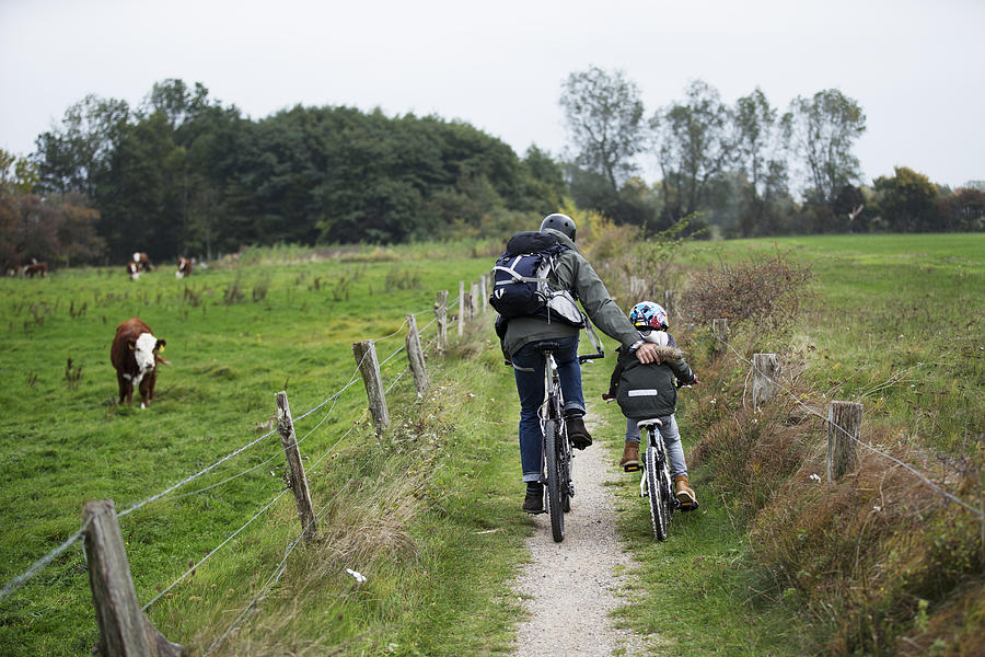 Father and son cycling together in nature Photograph by Thomas Tolstrup